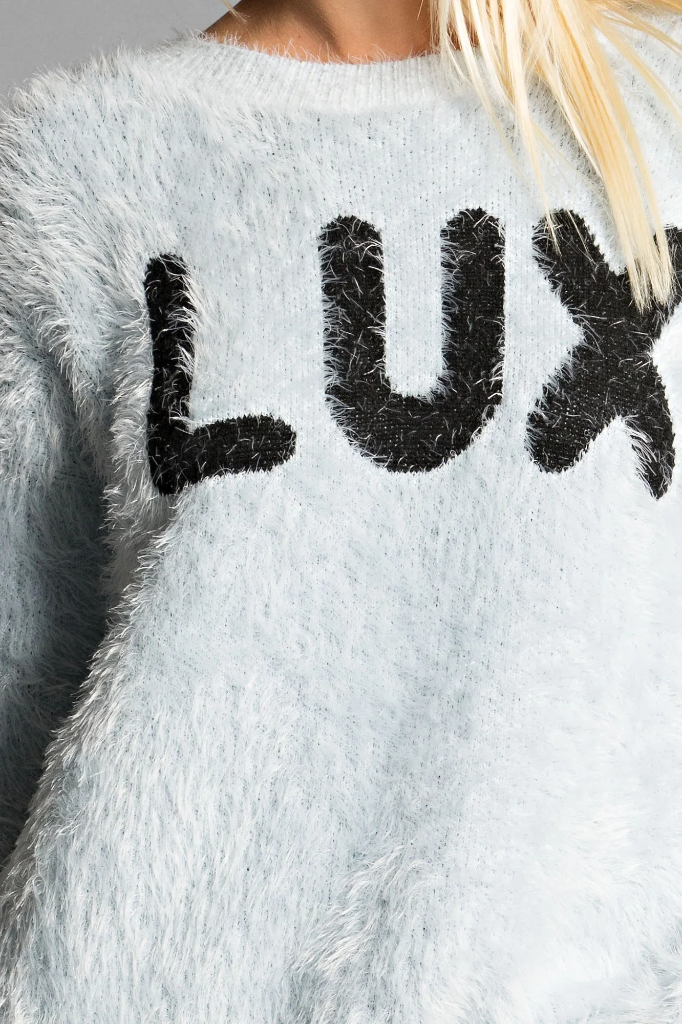 Person wearing a fuzzy gray sweater with 'luv' lettering — Urban Nation knitwear